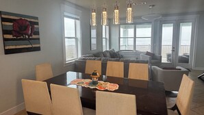 Un comedor con una mesa de madera oscura, sillas tapizadas en beige y una isla central con asientos.