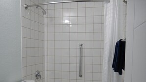 A bathroom with a toilet, sink, bathtub, and shower curtain.
