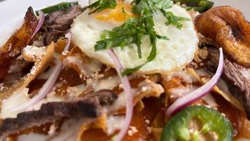 Un plato de comida con un huevo frito, carne y verduras.