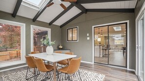 A dining area with a white table and four chairs, a patterned rug, and a ceiling fan. - Bright, Spacious 4BD Suburban Nest w/Garage & Yard, hosted by DenverStays (Arvada)