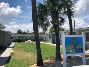Stroll through the serene residential area of Sand Reef, surrounded by palm trees and lush greenery.