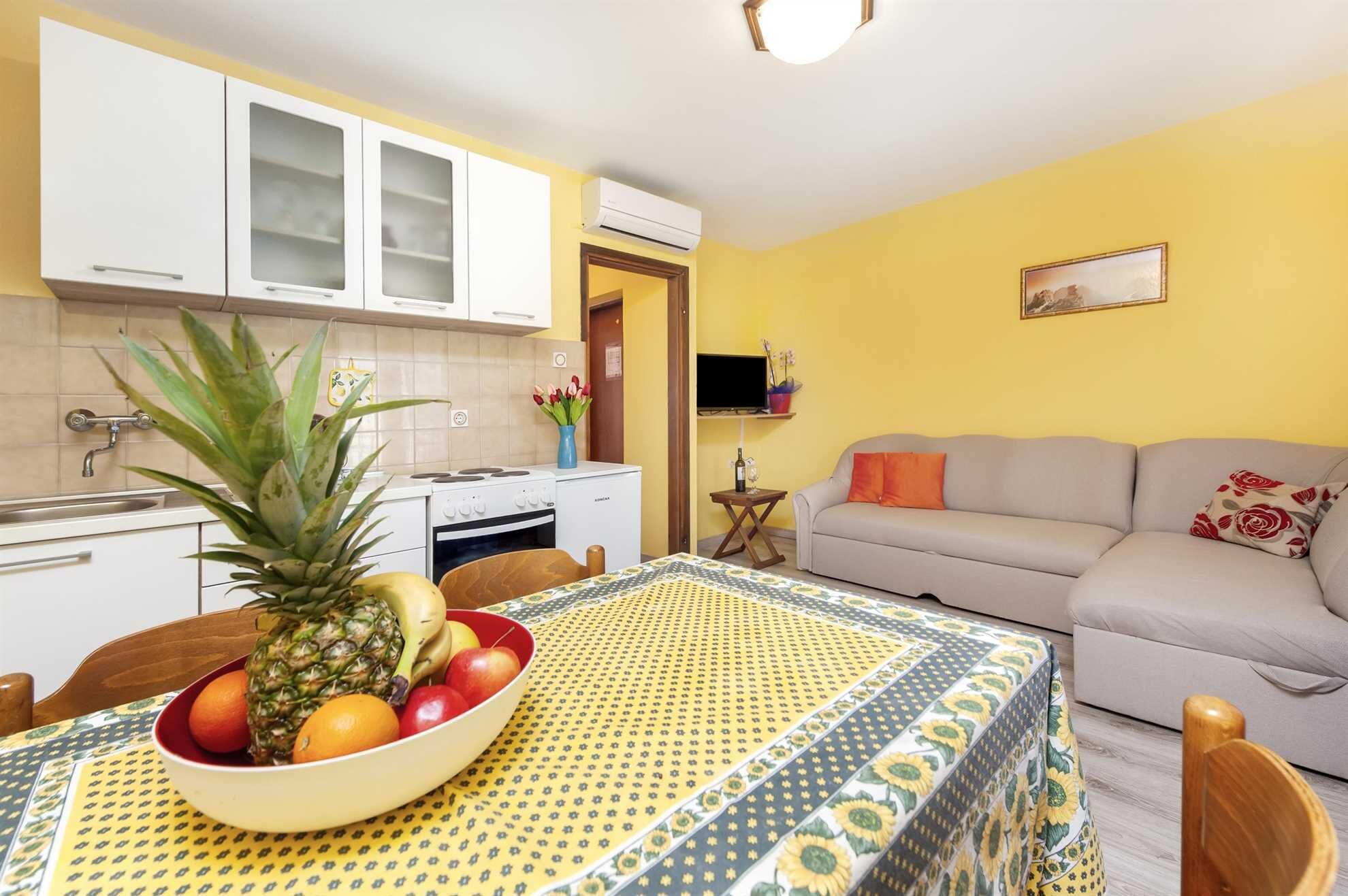 Un espacio habitable compacto con cocina, comedor y sofá.