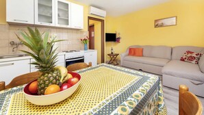 A compact living space with a kitchen, dining area, and a sofa.