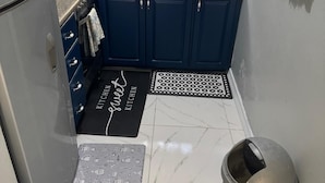 A compact kitchen with dark blue cabinets, a stainless steel sink, and a coffee maker. - Relax with us Casa de Columbus!
5- mins from the beach and other fun activities! (Ocho Rios)