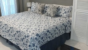 A bedroom with a bed, a nightstand, a lamp, and two paintings on the wall. - Relax with us Casa de Columbus!
5- mins from the beach and other fun activities! (Ocho Rios)