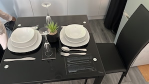 A dining table set with white plates, a wine glass, cutlery, and a small potted plant. Instructions for use are displayed on the table. - The Lodge Oldham (Oldham)