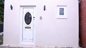 A white house with a decorative door, a small window, and a mailbox. - The Lodge Oldham (Oldham)