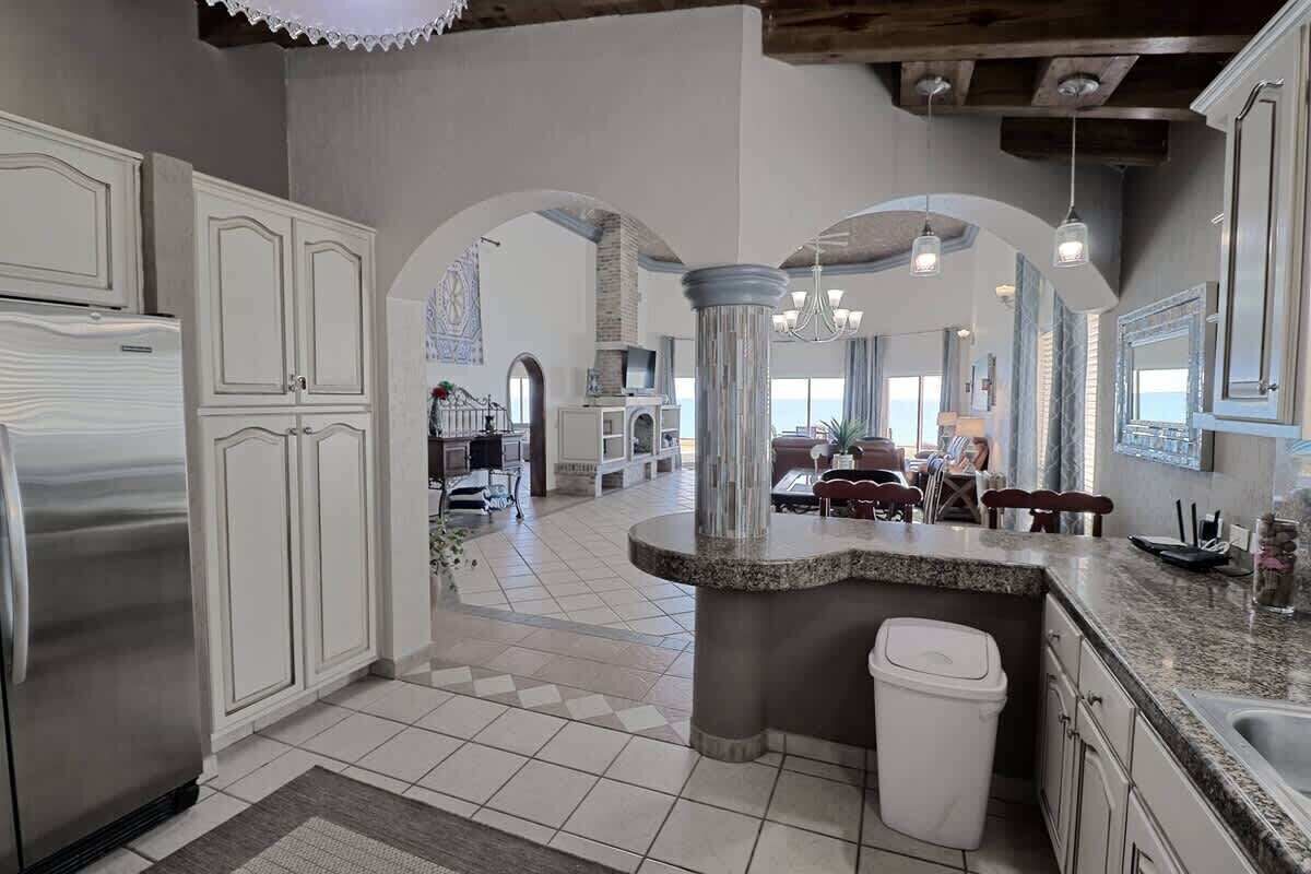 A spacious kitchen with white cabinetry, a granite countertop, and a central island.