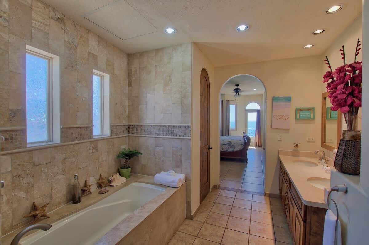 A bathroom with a bathtub, a sink, and a mirror.