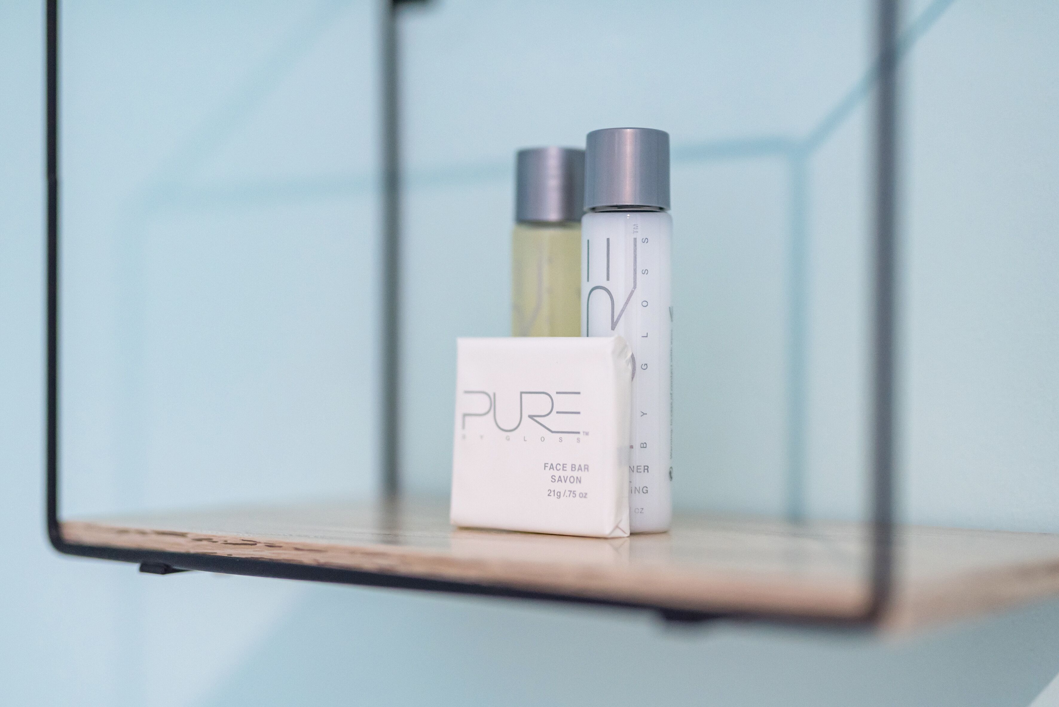 A shelf with a white box labeled "PURE" and two bottles.