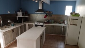 A kitchen with a central island, a stove, a microwave, and a refrigerator. - Maison a Louer Situé au Bord de la Dordogne (Saint-André-de-Cubzac)