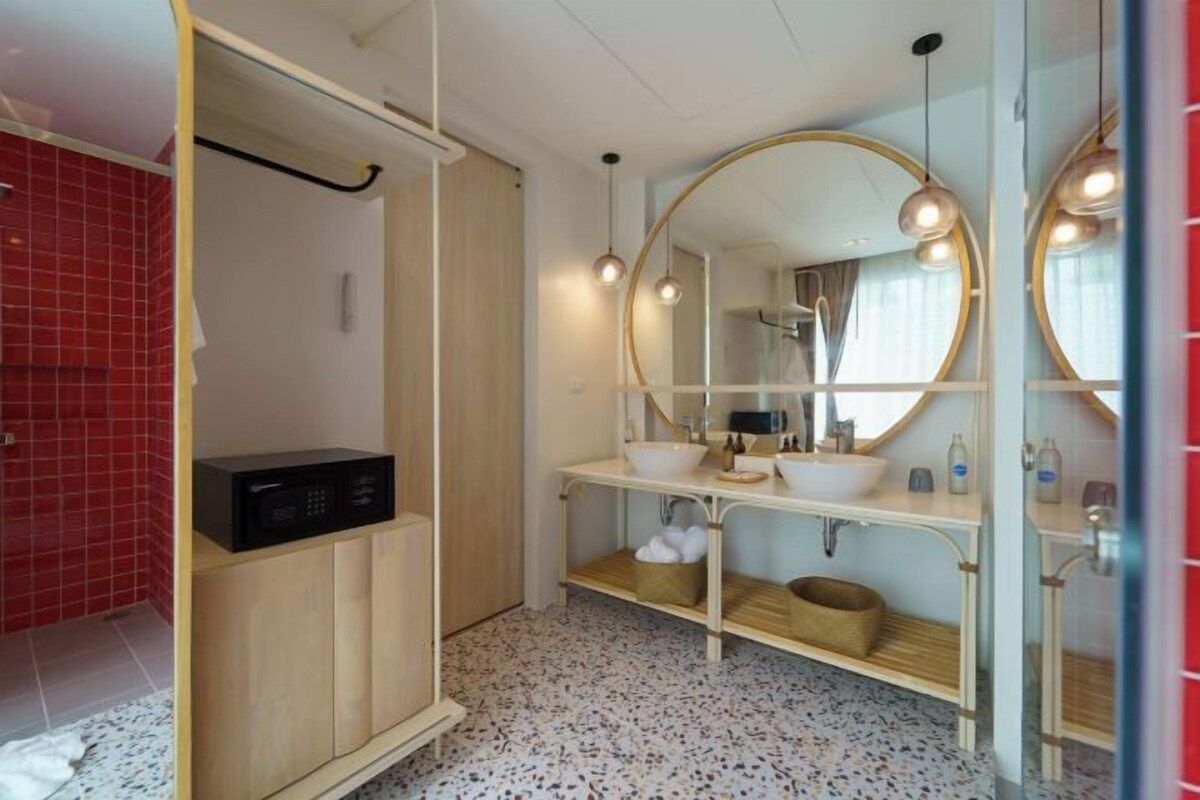 Een moderne badkamer met een houten kastje, een grote spiegel en een wastafel.