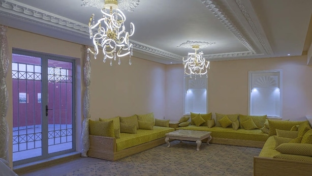 Un salón con un amplio sofá en forma de L, una mesa de centro y dos candelabros.