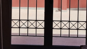 Habitación con puerta de vidrio corredera que da a un área exterior.