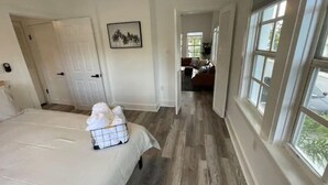 A bedroom with a bed, a bedside table, and a wall-mounted picture. - Modern 2BR Steps 2 Water Near Downtown! Fast Wifi (Lake Worth)