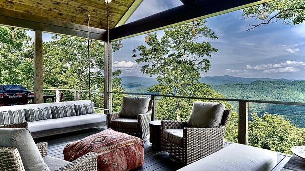 A covered outdoor seating area with wicker furniture and a view of the mountains. - 5 Star Luxury, Lake Access, Spectacular Views! (Bryson City)