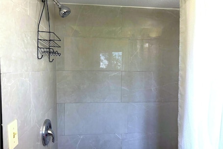 A shower with a handheld showerhead and a metal rack.. Hillcrest Motel By OYO Aurora IN Near Lawrenceburg