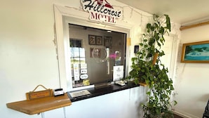 A Hillcrest Motel reception desk with a plant, a sign thanking guests for not smoking, and payment options displayed. - Hillcrest Motel By OYO Aurora IN Near Lawrenceburg (Aurora)