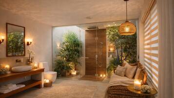 A modern bathroom with a glass shower enclosure, a wooden vanity, a large mirror, and a wicker sofa with a candle.