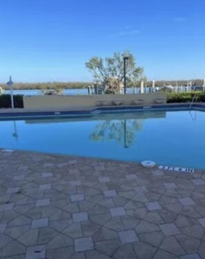 Surrounding the pool is a paved walkway with a hexagonal tile pattern.