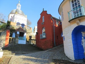 A street with a church, a red building, and a blue door.