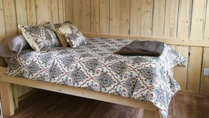 Una cama litera de madera con ropa de cama y almohadas estampadas.