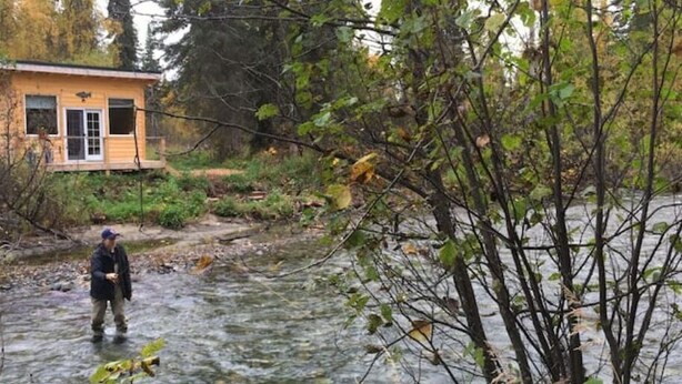 Una cabaña de madera junto a un río.