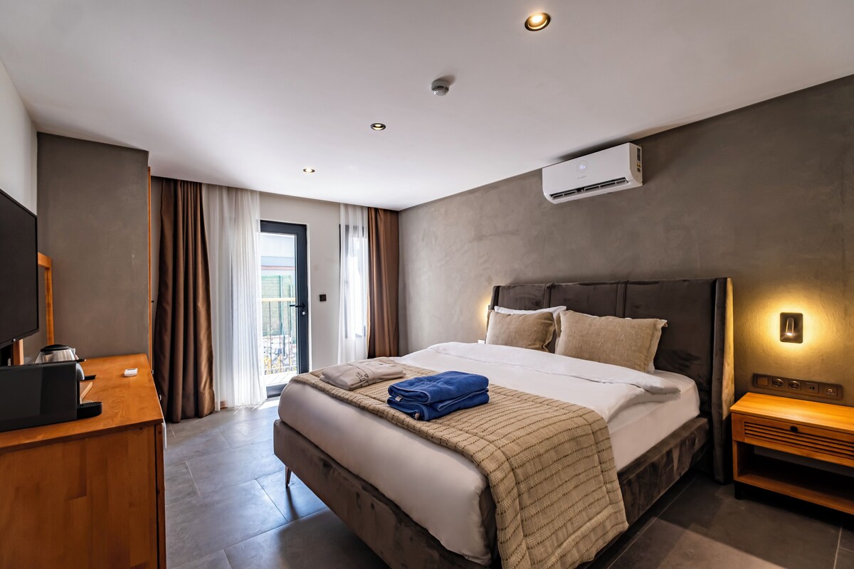 Une chambre d’hôtel moderne, dotée d’un grand lit, d’un bureau et d’une télévision.