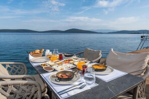 A table set for breakfast with a view of the water and hills. - Isolina Bodrum (Bodrum)