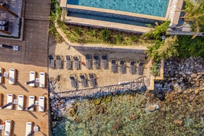 An aerial view of a resort with a pool, sun loungers, and a wooden deck. - Isolina Bodrum (Bodrum)