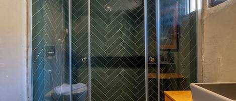 Un baño con cabina de ducha, inodoro y lavamanos.