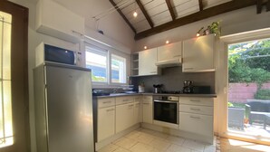 A kitchen with a refrigerator, stove, oven, and cabinets. - Typée, Accueillante et Confortable Maison (Pessac)