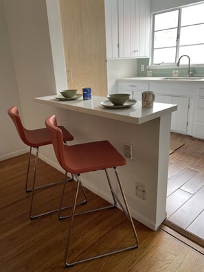 Kitchen area with a central island featuring a sink and a window above it, offering a clean and minimalist design.