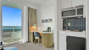 A hotel room with a balcony, a dining area, a kitchenette, and a view of the ocean. - Junior Suite 33rd Flr in Fontainebleau Miami Beach (Miami Beach)