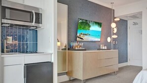 A modern bathroom with a sink, mirror, and a large TV mounted on the wall. - Junior Suite 33rd Flr in Fontainebleau Miami Beach (Miami Beach)