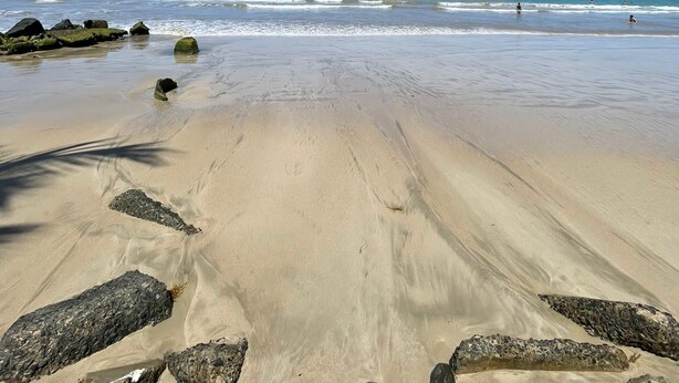 A beach with clear skies, calm waves, and scattered rocks. - Charming Isla Verde Studio (Carolina)