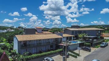 A residential building with a tiled roof, a swimming pool, and a sign indicating 'CAPITOLIO'.