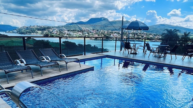 Una piscina con sillas de descanso y vistas a un paisaje montañoso.