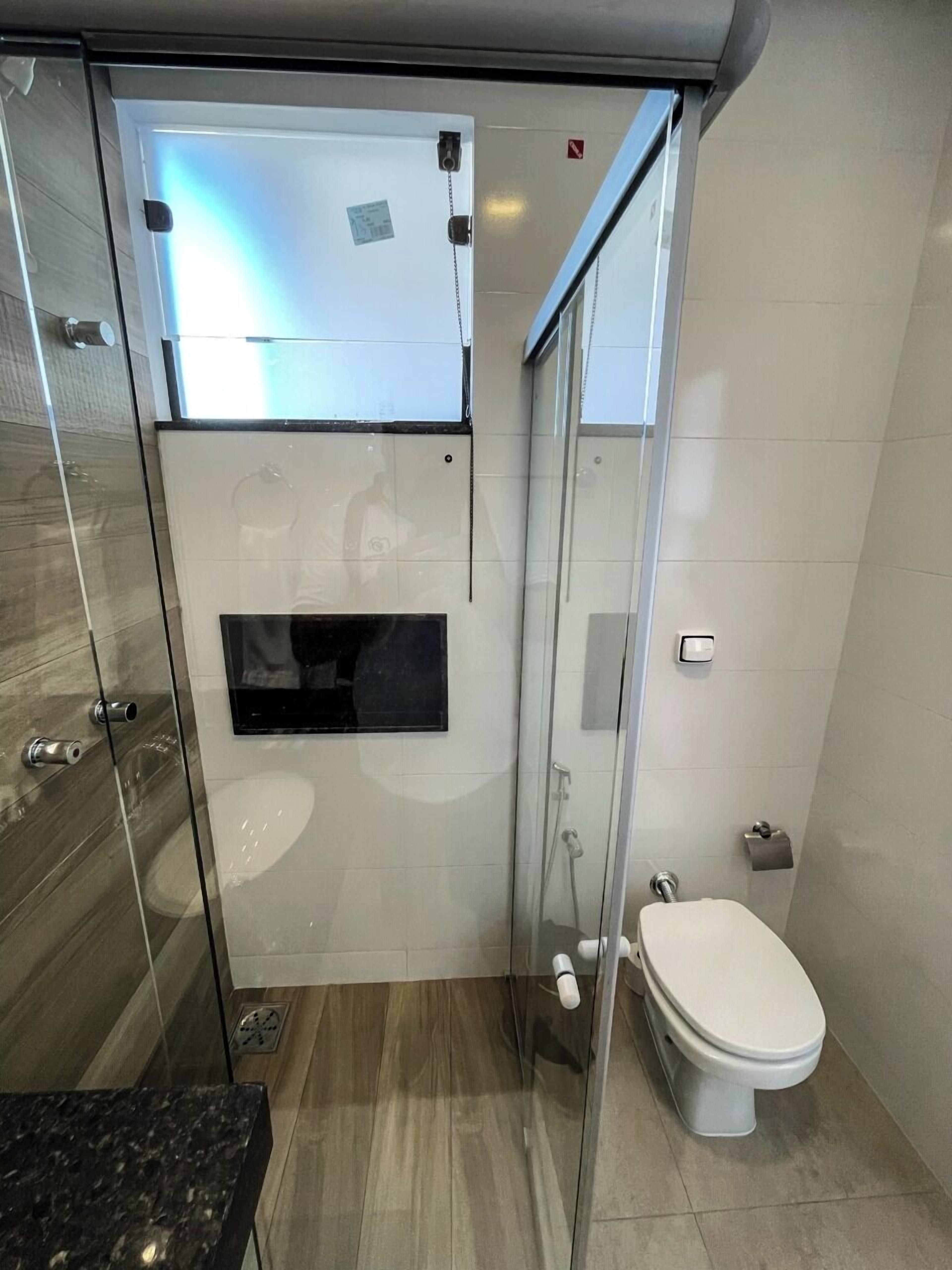 Un bany modern amb una cabina de dutxa de vidre, un vàter i un lavabo.