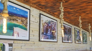 Fotografías enmarcadas sobre una pared de ladrillo, techo de madera y mostrador de madera.