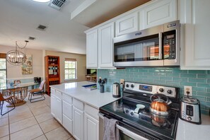 Enjoy cooking in this well-equipped kitchen with a stove, kettle, toaster, and microwave, and dine at the adjacent glass table.