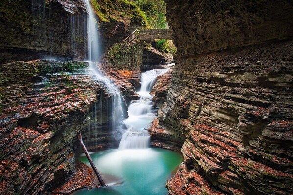 A waterfall cascading into a pool surrounded by rocky cliffs.