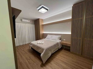 Ein modernes Schlafzimmer mit Bett, Nachttisch und Kopfteil.