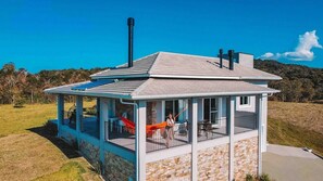 A small, single-story building with a covered porch, stone walls, and a chimney. - Casa Paraíso do Sol - Rancho Queimado (Rancho Queimado)
