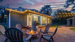 A house with a covered patio, outdoor seating, and a fire pit.