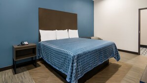 Une chambre d’hôtel avec un lit, une table de chevet et un téléphone.