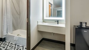 Une salle de bain moderne avec une baignoire, un lavabo et un miroir.