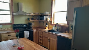 Une cuisine avec des meubles de rangement en bois, un réfrigérateur en acier inoxydable, un four à micro-ondes et une cuisinière.
