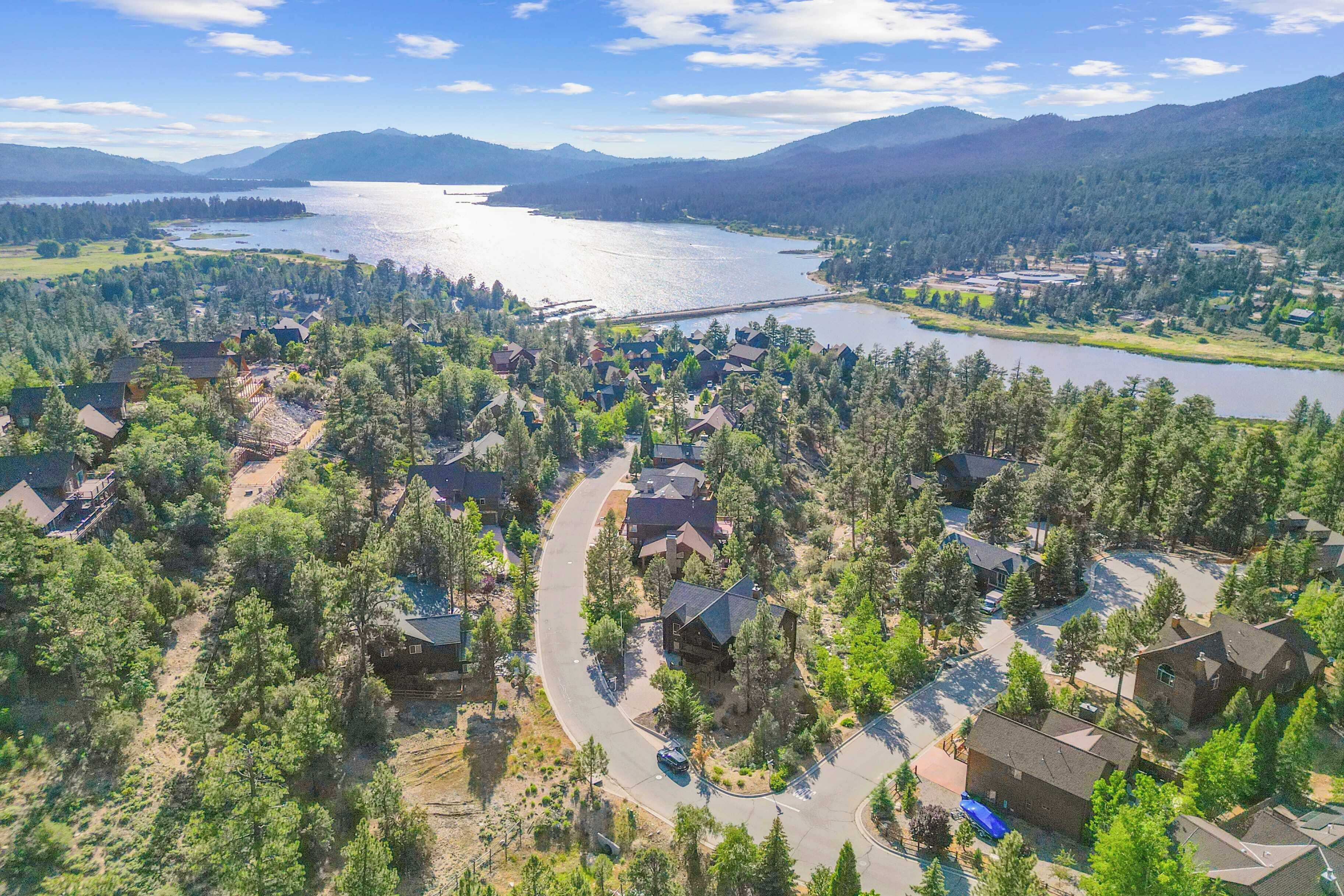 An aerial view of a residential area with houses, roads, and a lake.