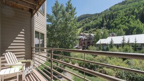 A balcony with a view of a forested mountain and a cluster of buildings. - Viking Lodge 216 by Avantstay Great Ski Access, Walk to Downtown (Telluride)